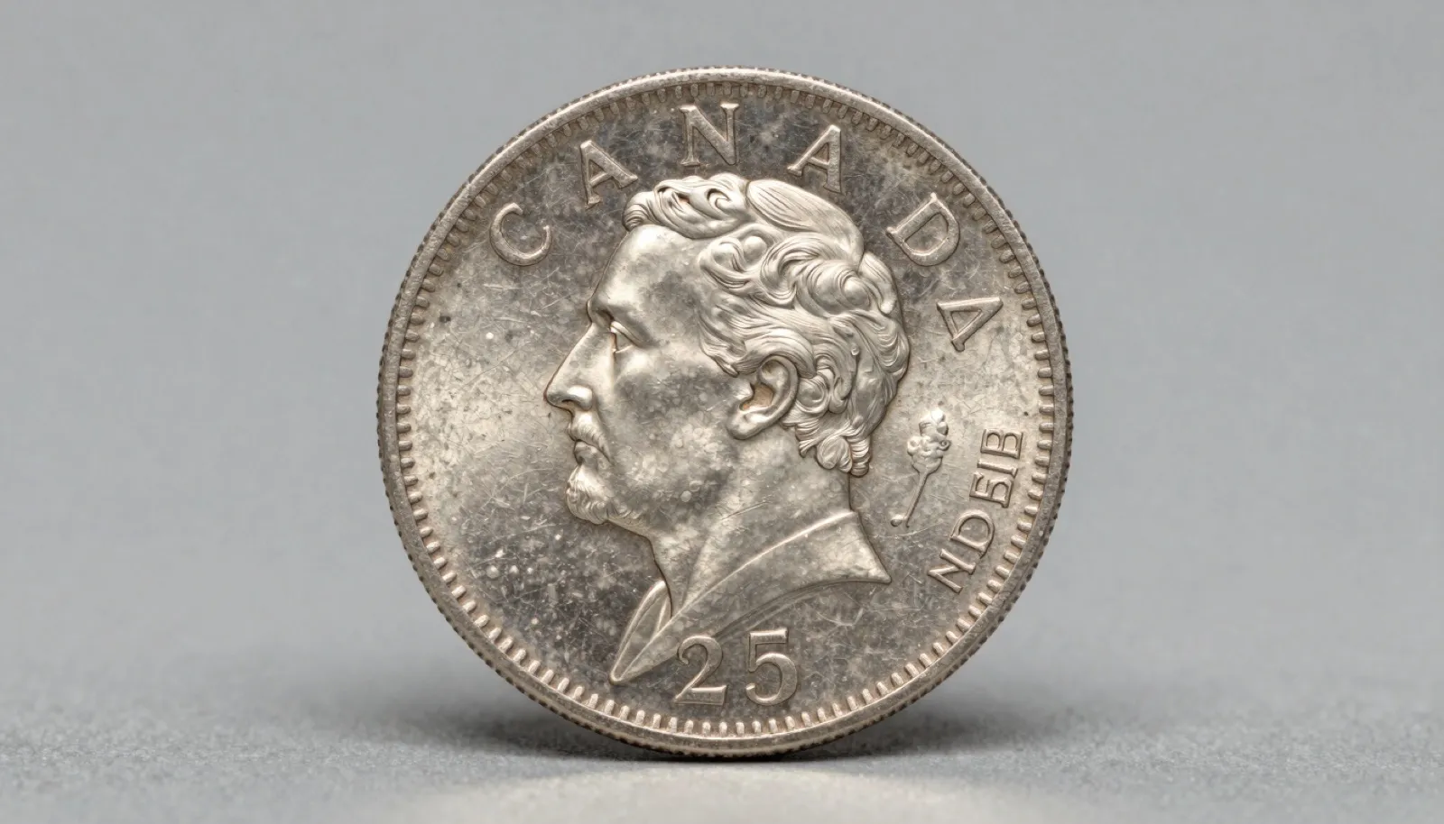 Pre-1968 Canadian silver quarter showing Victoria portrait and detailed caribou reverse on a neutral studio surface