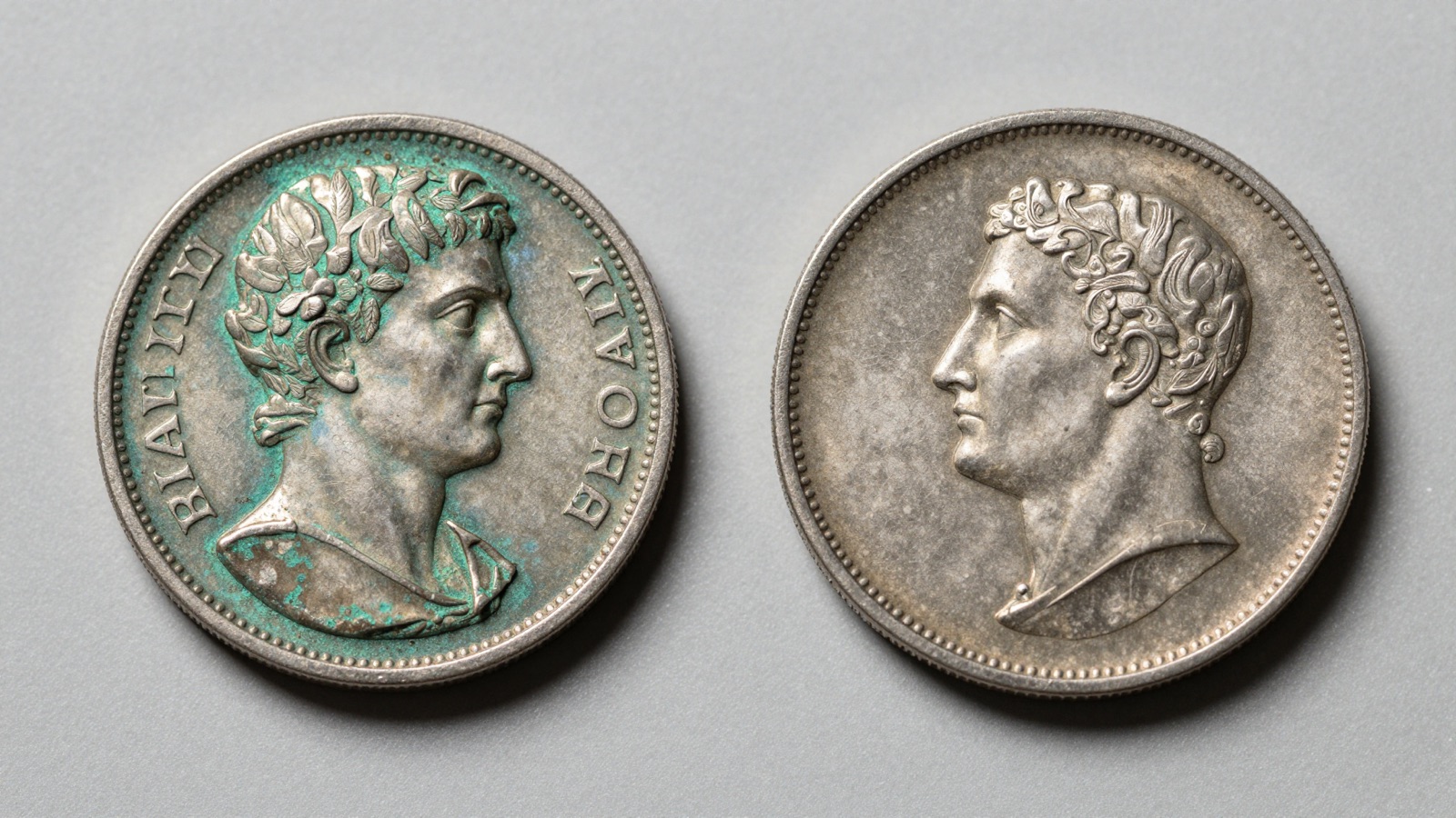 Ancient Roman bronze coin and medieval hammered silver penny side by side on a neutral studio surface