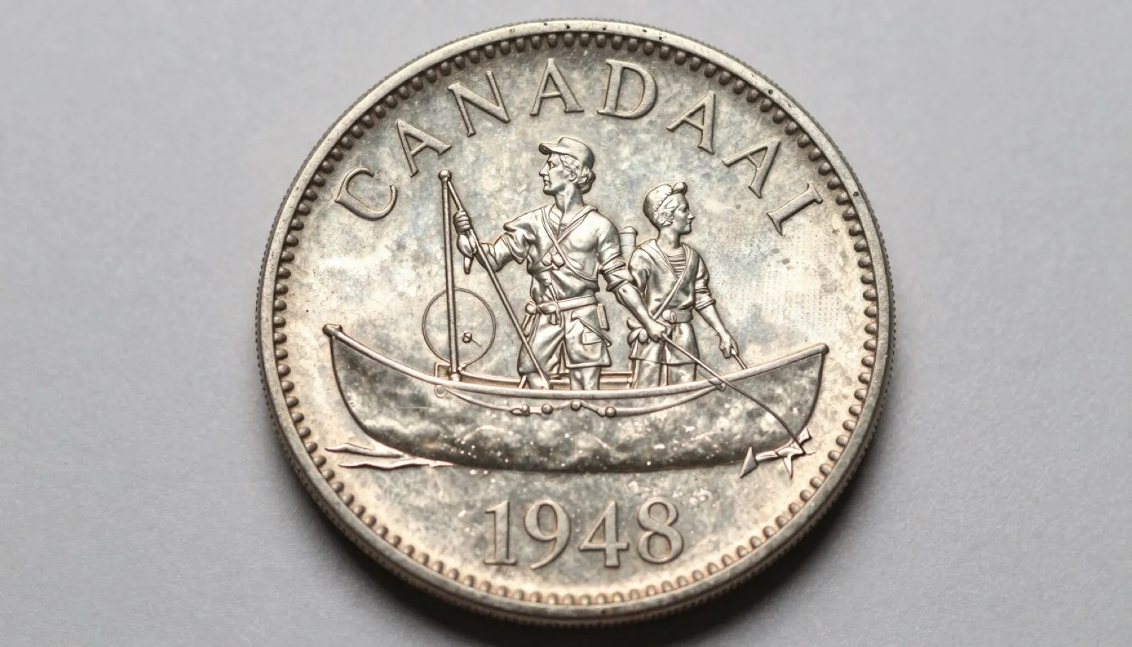 Uncirculated 1948 Canadian voyageur silver dollar displayed on neutral studio surface showing key date variety