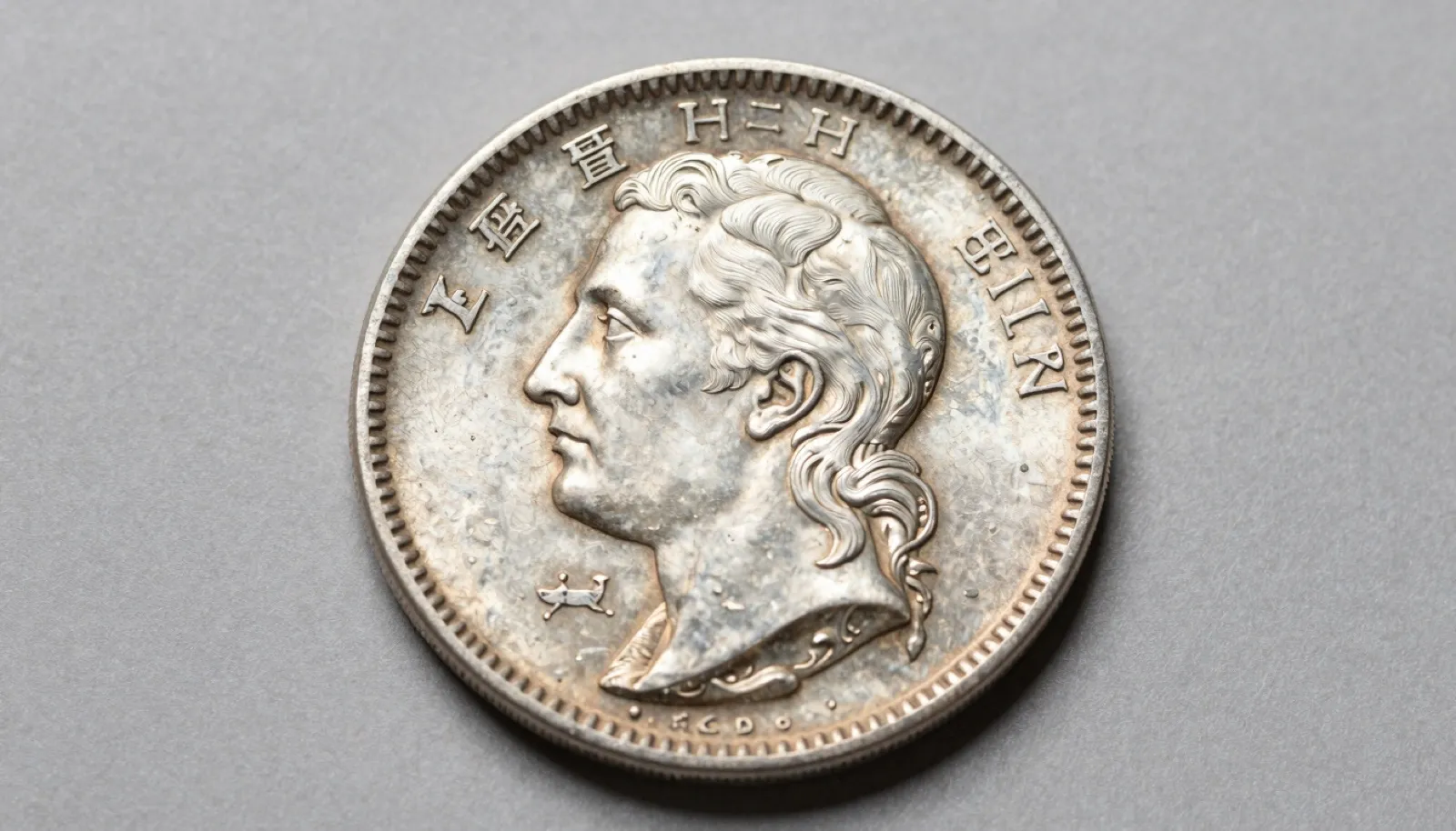 Macro photograph of a counterfeit cast silver coin showing surface pitting and a faint edge seam line
