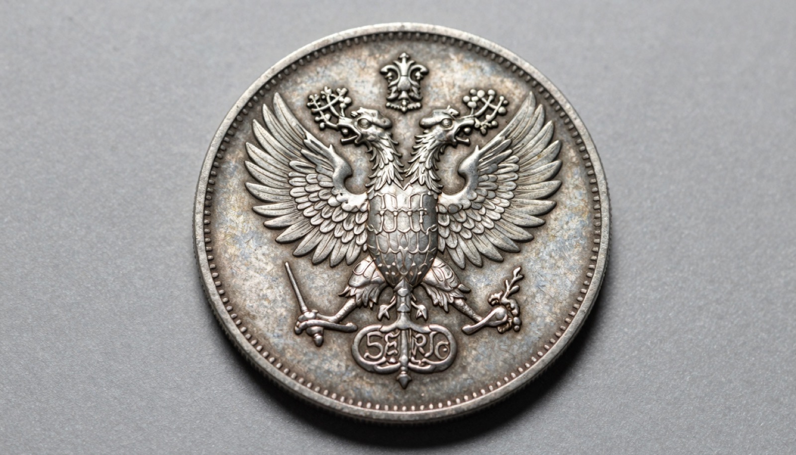 Imperial Russian silver ruble with double-headed eagle on a neutral studio surface under soft directional light