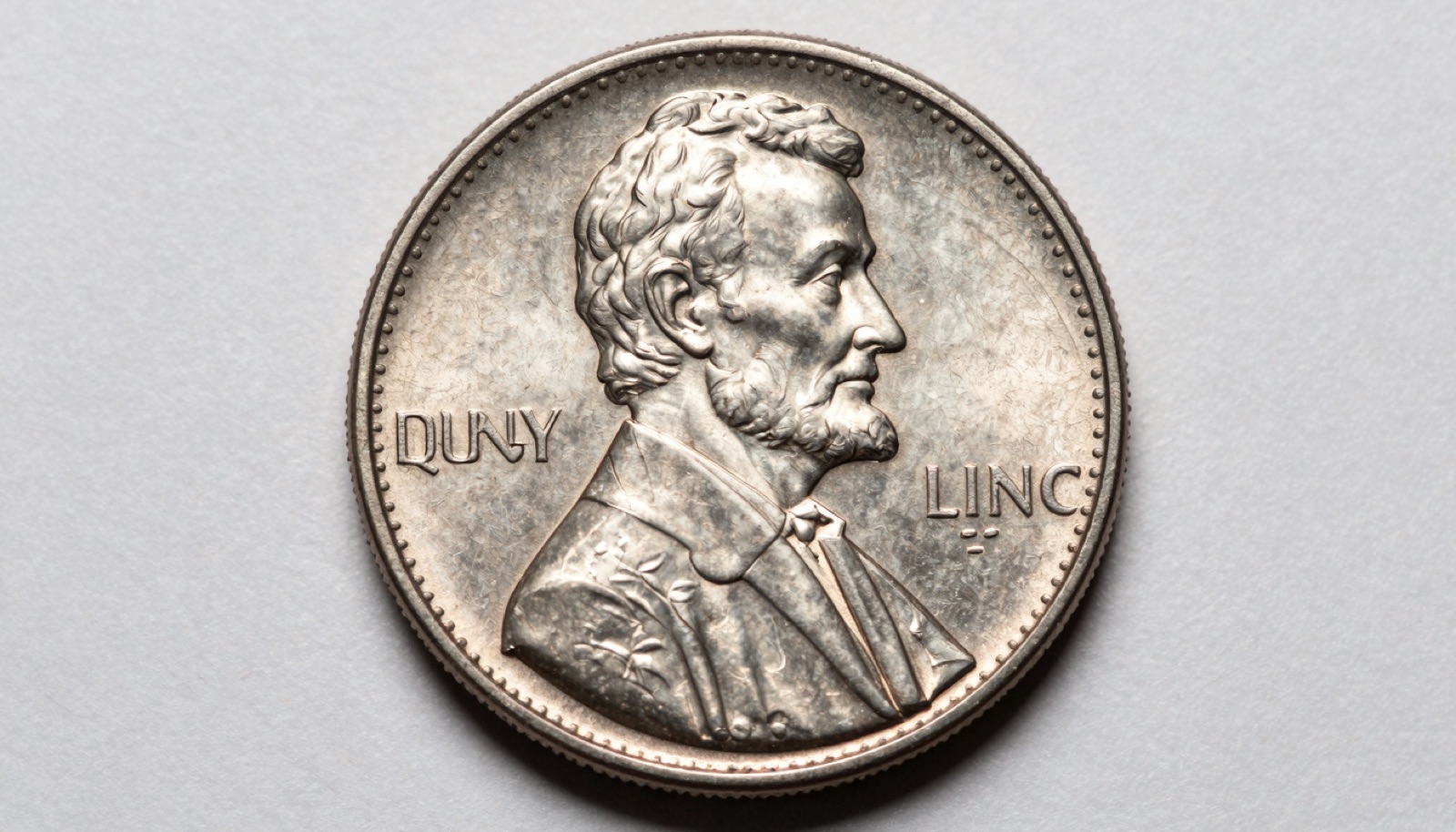Macro photo of a Lincoln cent showing a curved clipped planchet error with a crescent slice missing