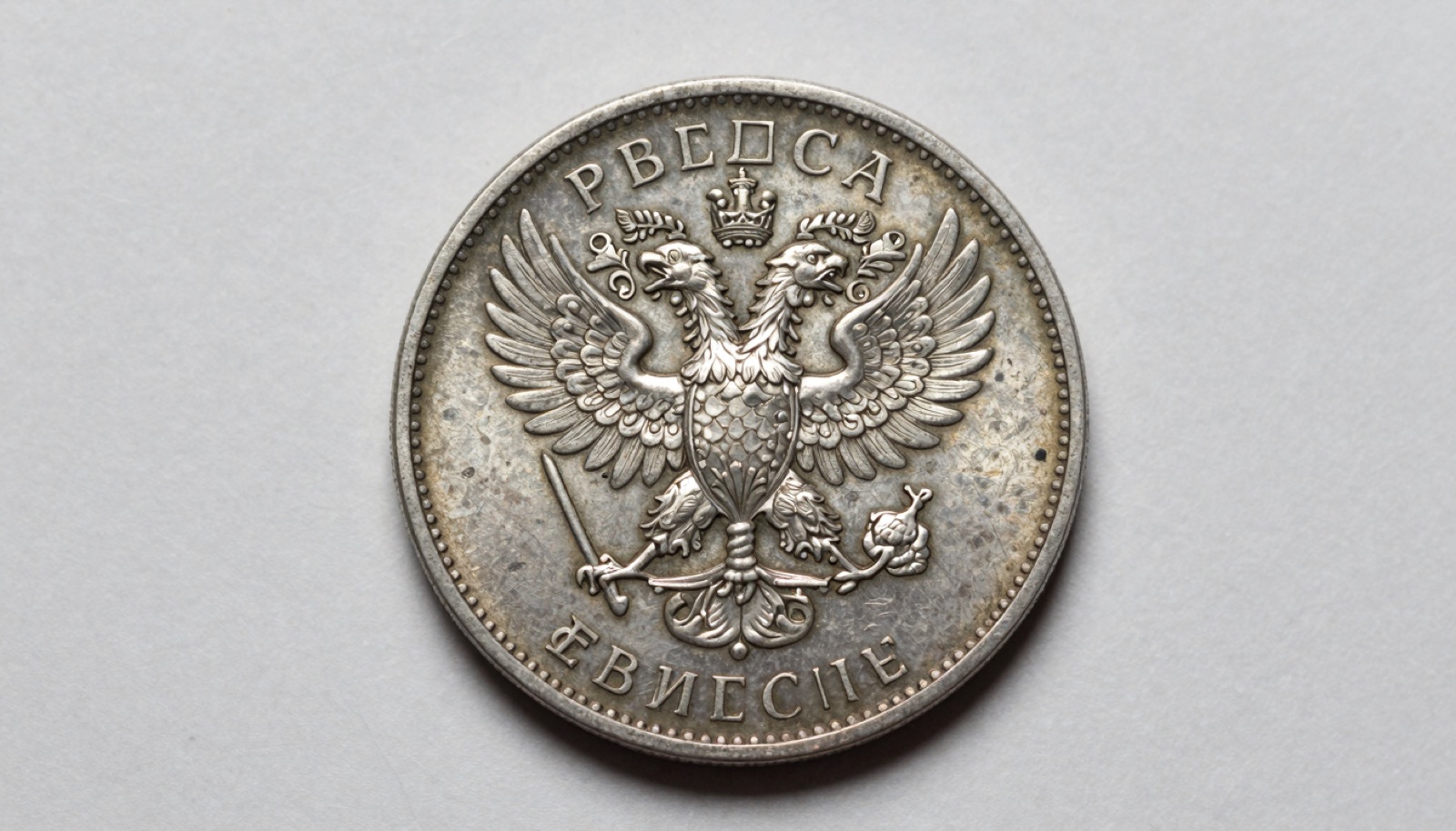 Authentic antique Russian imperial silver ruble showing the tsarist double-headed eagle and Cyrillic legend in macro detail